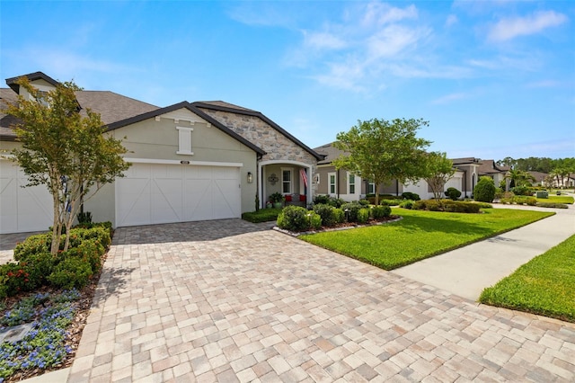 view of front of property with stucco siding, decorative driveway, a front yard, and a garage
