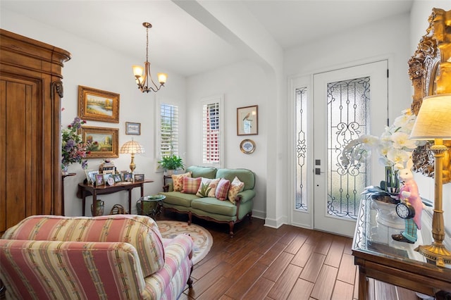 interior space featuring baseboards, a chandelier, and dark wood finished floors