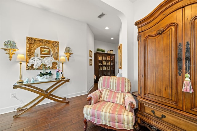 sitting room with visible vents, wood finished floors, baseboards, recessed lighting, and arched walkways