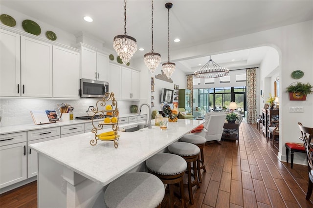 kitchen featuring a sink, appliances with stainless steel finishes, a notable chandelier, and tasteful backsplash