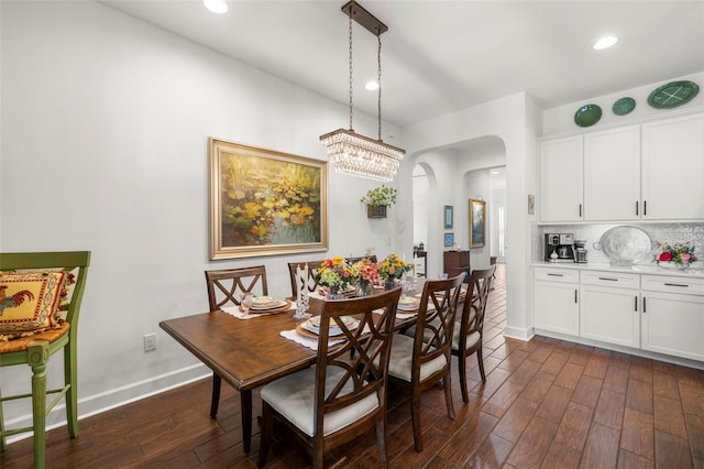 dining space with recessed lighting, arched walkways, baseboards, and dark wood-style floors