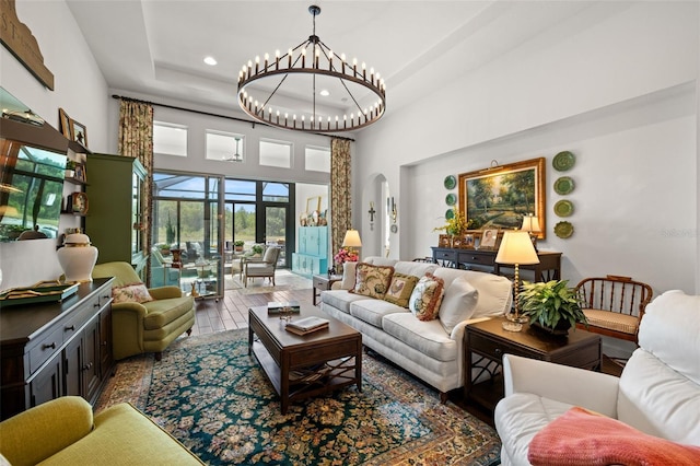 living room featuring arched walkways, a high ceiling, recessed lighting, and a chandelier