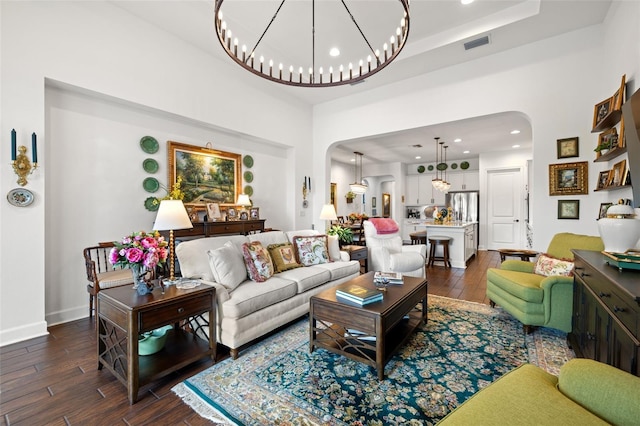 living room featuring arched walkways, dark wood finished floors, recessed lighting, baseboards, and visible vents