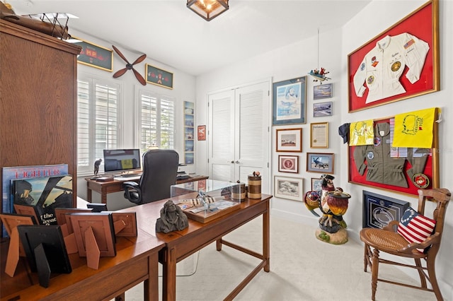carpeted office space featuring baseboards