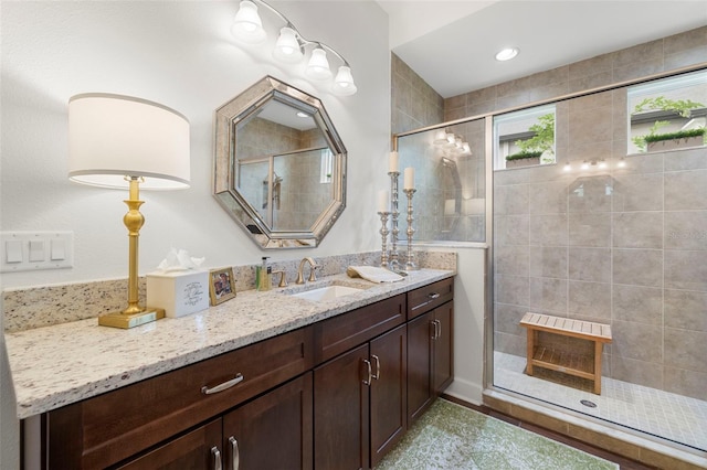 full bathroom with vanity and tiled shower