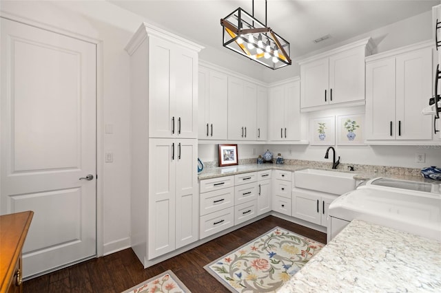 kitchen with white cabinets, light stone countertops, and dark wood-style floors