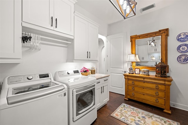laundry area with cabinet space, dark wood-style flooring, visible vents, and washing machine and dryer