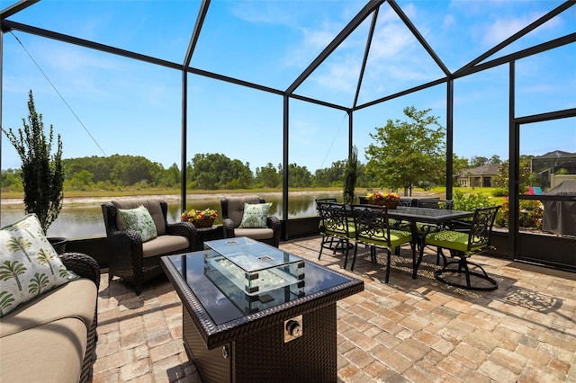 view of patio with glass enclosure, a water view, outdoor lounge area, and outdoor dining space