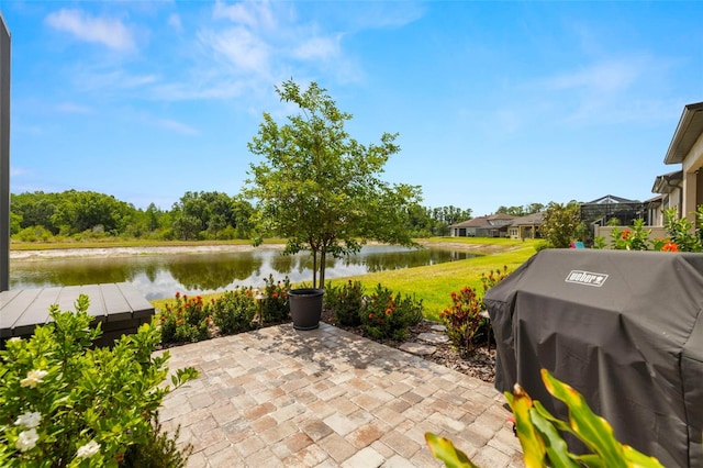 view of patio with a water view and a grill
