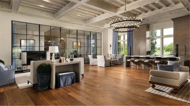 living area with beam ceiling, an inviting chandelier, and dark wood finished floors