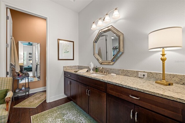 bathroom featuring vanity, baseboards, and wood finished floors