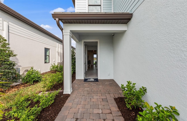 property entrance featuring ac unit and stucco siding