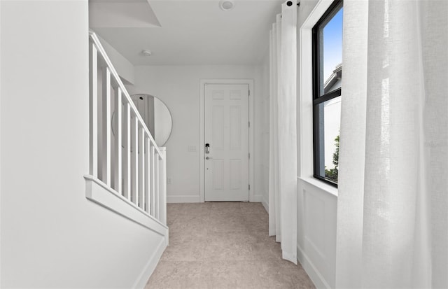 hall featuring baseboards and stairway