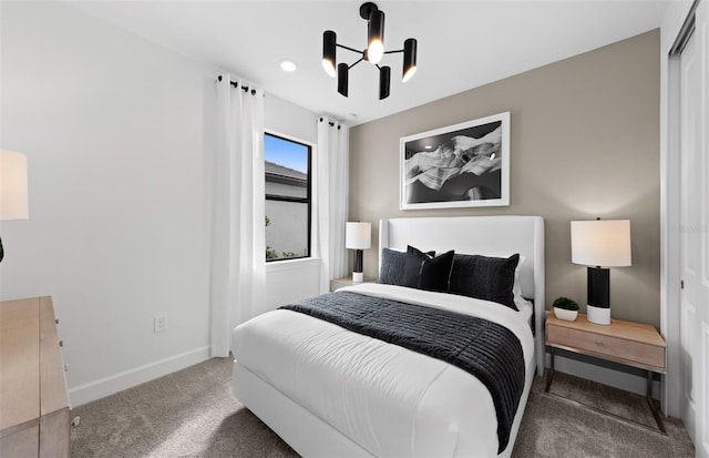 bedroom with carpet floors, baseboards, and an inviting chandelier