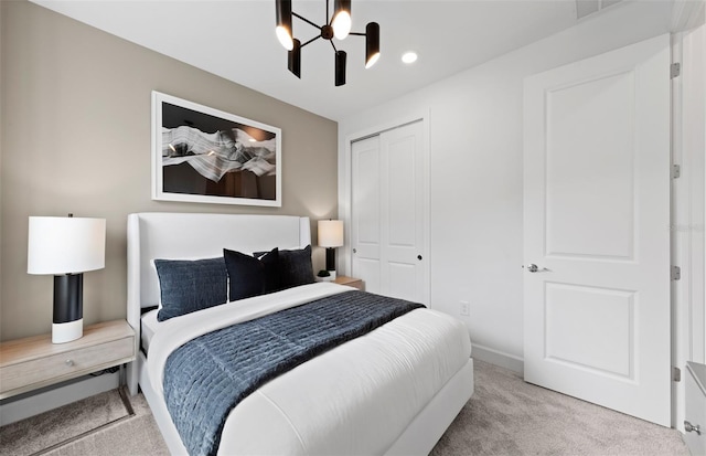 carpeted bedroom featuring a closet, visible vents, baseboards, recessed lighting, and a chandelier