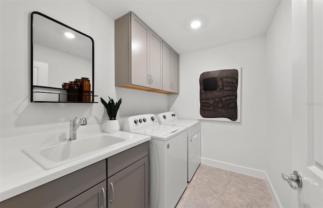 laundry room with cabinet space, a sink, recessed lighting, baseboards, and washing machine and dryer