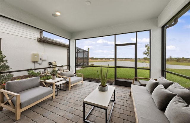 sunroom featuring a water view and outdoor lounge area
