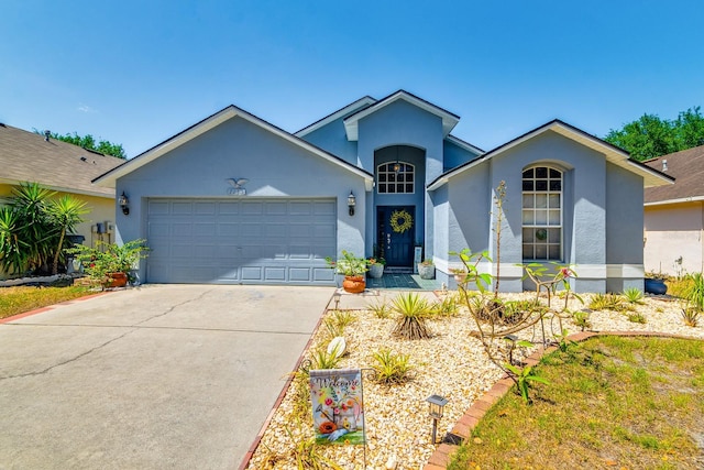 ranch-style house featuring an attached garage, stucco siding, and concrete driveway