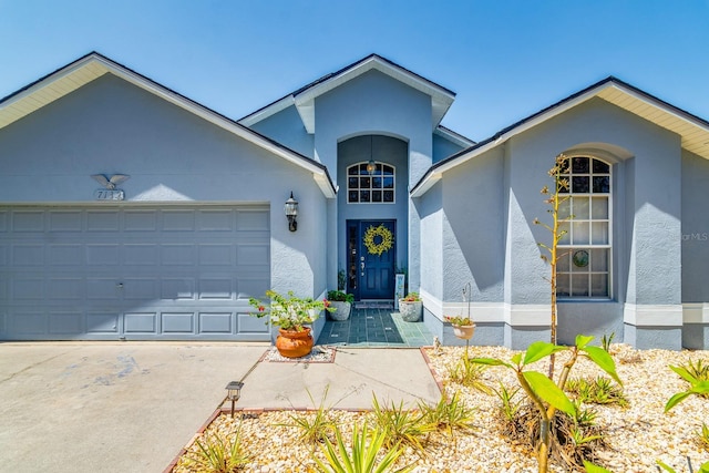 ranch-style home with an attached garage, stucco siding, and driveway