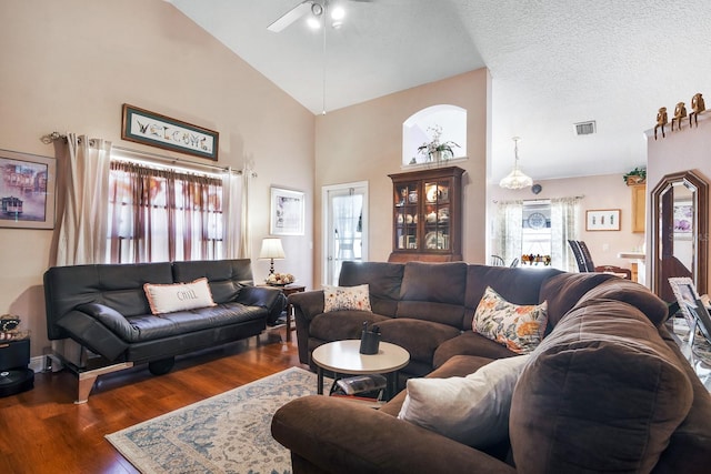 living room with high vaulted ceiling, a ceiling fan, wood finished floors, and visible vents