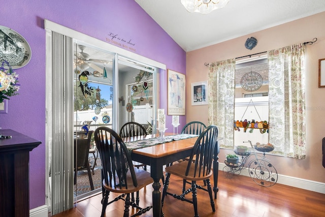 dining space with plenty of natural light, wood finished floors, and vaulted ceiling