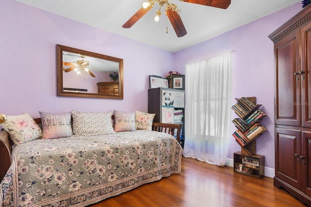 bedroom featuring baseboards, ceiling fan, and dark wood-style floors