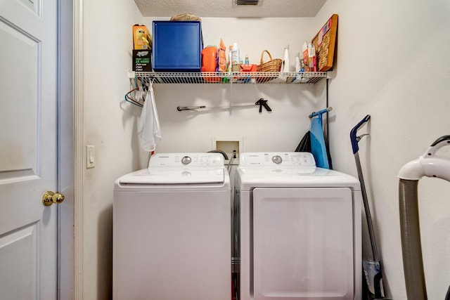 washroom featuring laundry area, visible vents, and washing machine and clothes dryer
