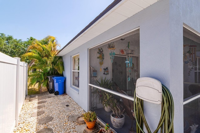 view of home's exterior featuring stucco siding and fence