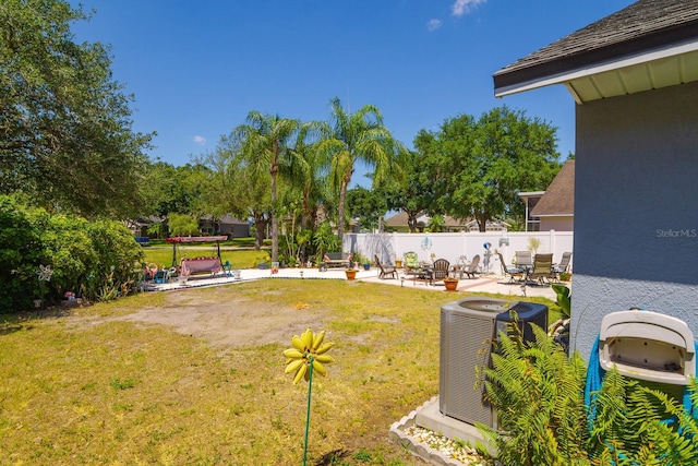 view of yard featuring central AC, fence, and a patio area