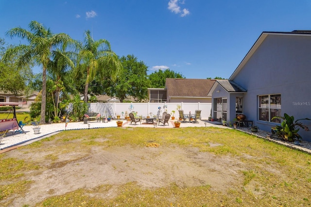 view of yard featuring a patio area, an outdoor fire pit, and fence