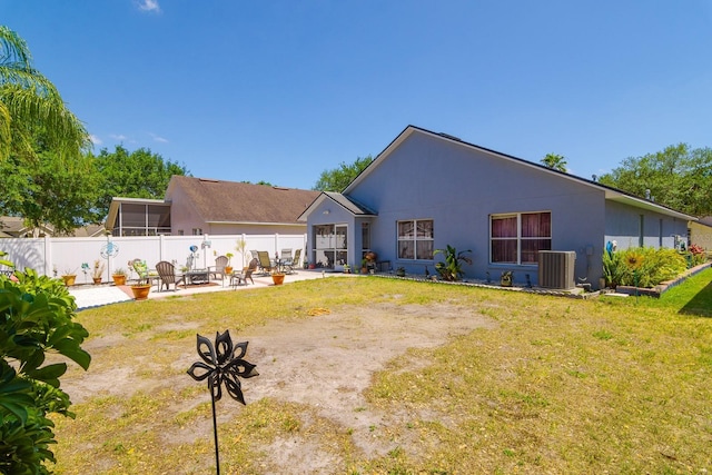back of property with fence, an outdoor fire pit, cooling unit, a patio area, and a lawn