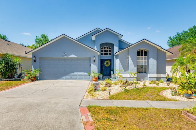 ranch-style home with stucco siding, concrete driveway, and a garage