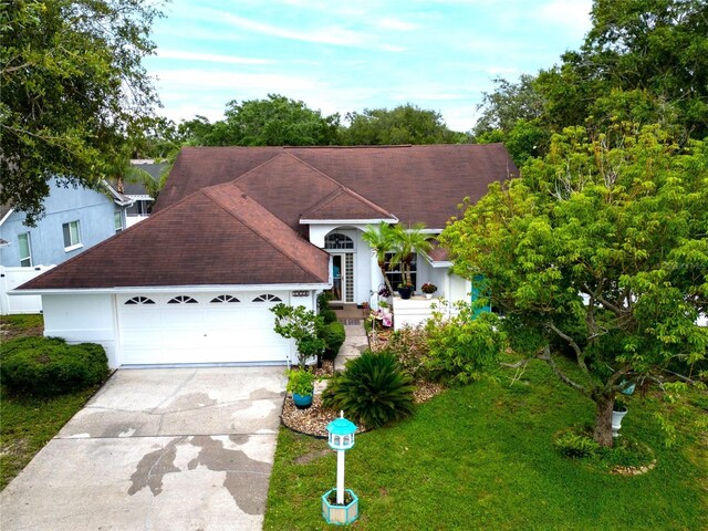 1424 Ridge Shore Dr, Tarpon Springs, FL 34689 - ranch-style home with roof with shingles, a garage, driveway, and a front lawn