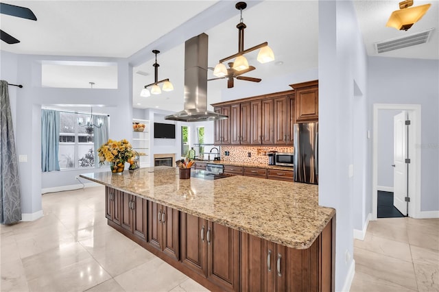 1424 Ridge Shore Dr, Tarpon Springs, FL 34689 - kitchen with island exhaust hood, stainless steel appliances, ceiling fan, and decorative backsplash