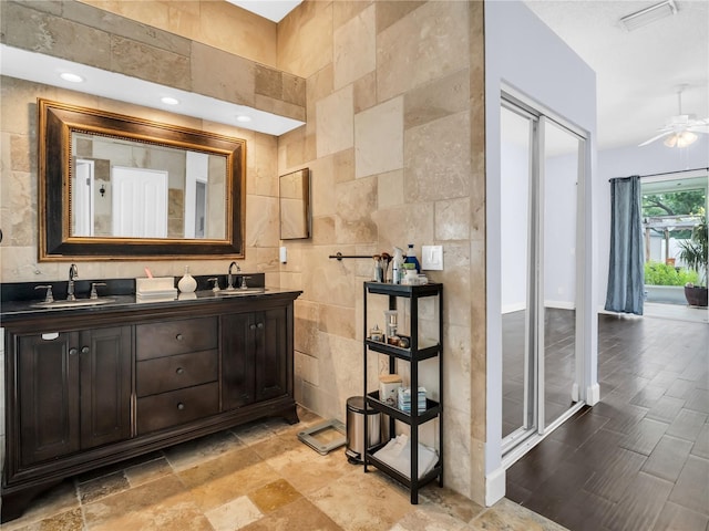 1424 Ridge Shore Dr, Tarpon Springs, FL 34689 - full bathroom with double vanity, ceiling fan, and tile walls