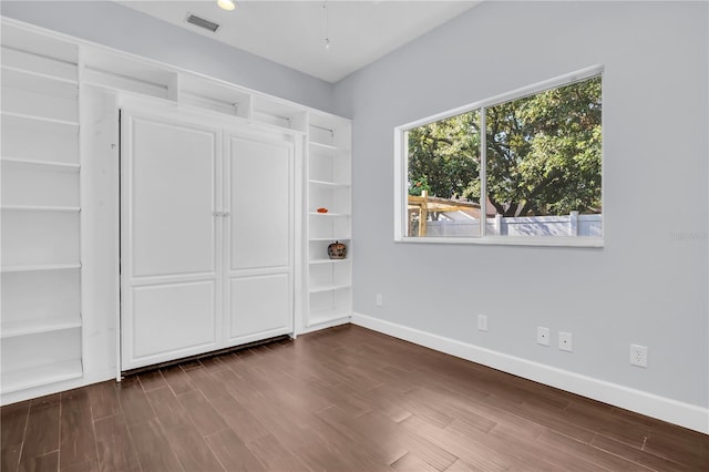 1424 Ridge Shore Dr, Tarpon Springs, FL 34689 - unfurnished bedroom with baseboards and dark wood-style flooring