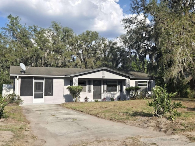 917 Adamson Ct, Lake Alfred, FL 33850 - ranch-style house featuring a front lawn, driveway, a shingled roof, and view of wooded area