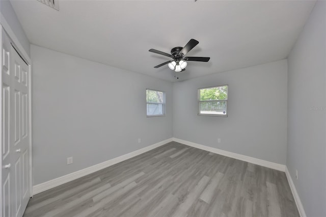 unfurnished bedroom with baseboards, ceiling fan, a closet, and wood finished floors