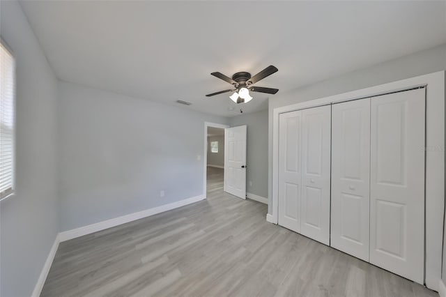 unfurnished bedroom with light wood-style floors, baseboards, multiple windows, and visible vents