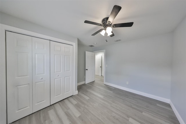 unfurnished bedroom with a closet, baseboards, visible vents, and light wood-type flooring