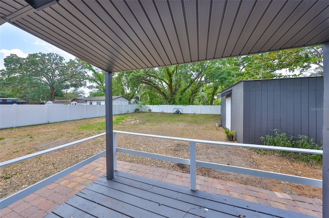 wooden deck featuring an outdoor structure and a fenced backyard