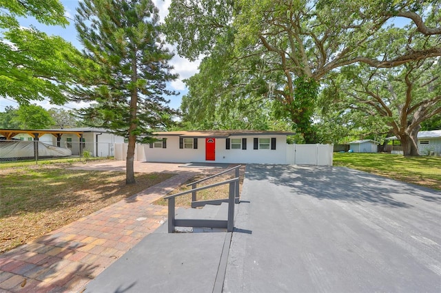 view of front of house featuring fence, driveway, and a front yard