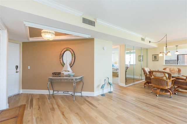 interior space featuring visible vents, baseboards, crown molding, and wood finished floors