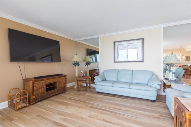 living room featuring crown molding, baseboards, and light wood finished floors