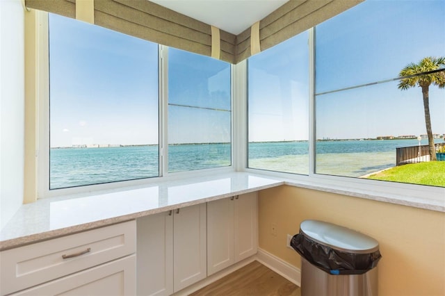 unfurnished sunroom with a water view and a wealth of natural light
