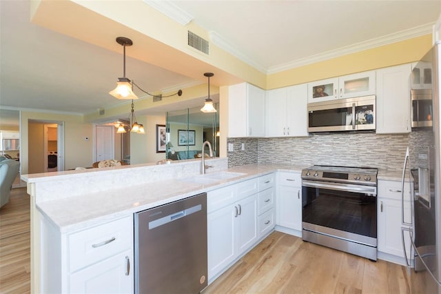kitchen featuring visible vents, ornamental molding, light stone countertops, a sink, and stainless steel appliances
