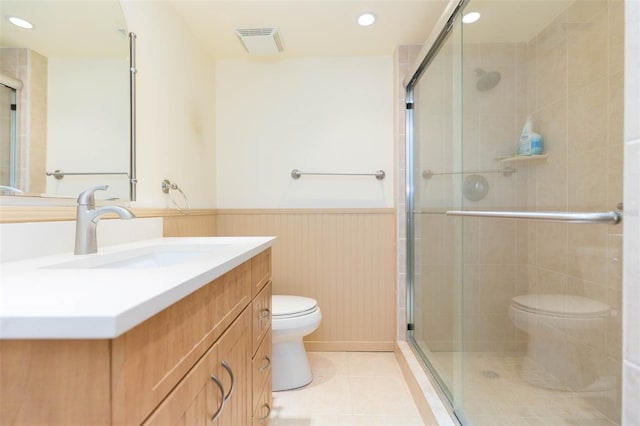 bathroom featuring visible vents, a shower stall, tile patterned floors, a wainscoted wall, and toilet