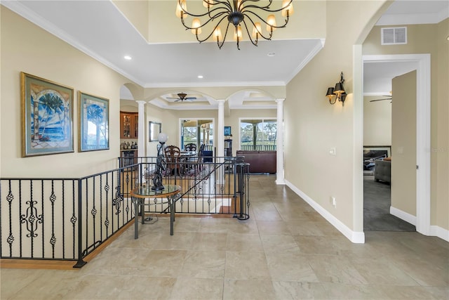 hall featuring decorative columns, visible vents, crown molding, an upstairs landing, and an inviting chandelier