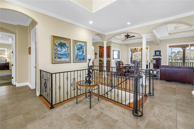hall featuring ornamental molding, ornate columns, recessed lighting, arched walkways, and an upstairs landing