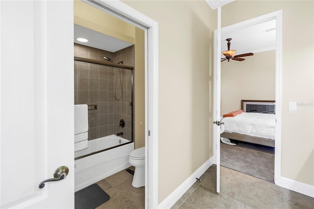 ensuite bathroom with ceiling fan, tile patterned flooring, toilet, enclosed tub / shower combo, and baseboards